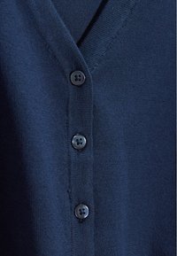 Mornarsko moder cardigan z V-izrezom, gladko teksturo in petimi črnimi gumbi spredaj za zavezovanje.