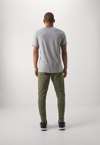 Nike Performance TAPER - Pantalones deportivos - medium olive/black
