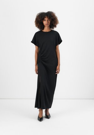 Black maxi dress with a round neckline, short sleeves, side ruching detail, and a thigh-high slit. Made from soft fabric.