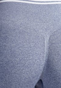 Marineblaue Sportleggings aus einem strukturierten, weichen Stoff. Sie haben einen gerippten, hohen Bund und subtile Farbvariationen im Material.