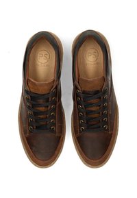 Zapatillas de cuero marrón y textil con acentos negros, puntera redonda, ojales metálicos, cordones negros y un patrón texturizado en los lados.