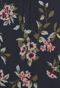 Tissu floral en marine foncé présentant de grandes fleurs roses et rouges avec des feuilles vertes. Texture lisse avec un motif subtil.