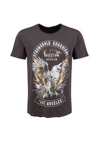 Camiseta negra de algodón con un diseño gráfico de un águila con rayos, texto circular y un dobladillo curvado.