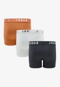 Drei Paar Boxershorts: orange, weiß und schwarz. Jedes hat eine weiche, glatte Textur mit kontrastierenden elastischen Taillenbünden, die das "Jordan"-Logo zeigen.