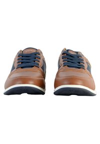 Zapatillas de cuero marrón con acentos en navy, que presentan suelas blancas, forma de punta redonda y cordones gruesos. Superficie texturizada y branding visible.