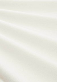 Hladká smetanově bílá látka s jemnými diagonálními záhyby a jemnou tkanou strukturou.