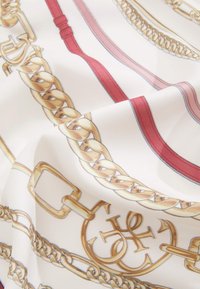 Zijden stof met een patroon van een gouden ketting en rode band op een witte achtergrond, met gedetailleerde illustraties van gespen en schakels.