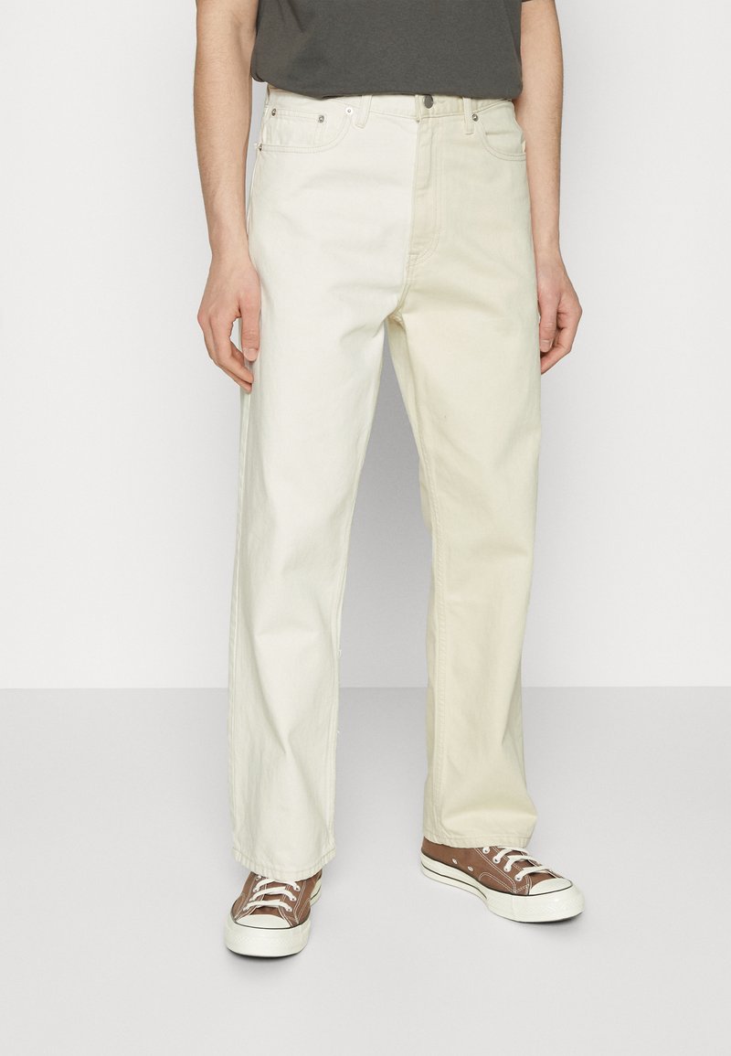 Light beige straight-leg jeans in cotton material with a smooth texture, featuring five pockets and silver-tone hardware.