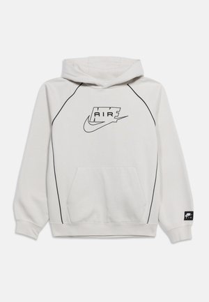 Sweat à capuche Nike Air gris clair avec logo noir contouré sur la poitrine, bandes noires sur les manches, poche kangourou à l'avant, et écusson de marque sur le poignet gauche.
