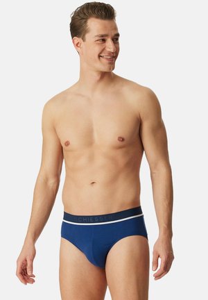 Marineblaue Slips aus weichem Baumwollmaterial, einem kontrastierenden weißen Bund mit Logo und einem engen, figurbetonten Design.