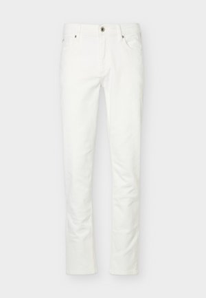 Strakke witte jeans met knoop- en ritssluiting aan de voorkant, vijf zakken en riemlussen, getoond tegen een effen lichte achtergrond.