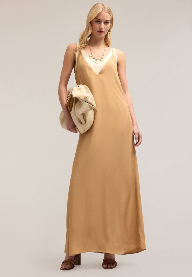 Maxikleid aus einem hellbraunen Stoff mit tiefem V-Ausschnitt und cremefarbenen Akzenten. Hat eine lockere Passform und reicht bis zu den Knöcheln. Zubehör beinhaltet eine Clutch.