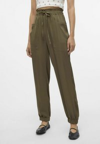Pantalons légers couleur olive, avec taille élastique, deux grandes poches latérales et bas fuselés. Texture lisse, adaptés au style décontracté.