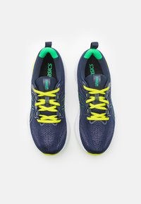 Scarpe da ginnastica Asics, parte superiore blu navy con motivo texture, lacci giallo neon, dettagli verdi, suola bianca, soletta imbottita, design leggero.