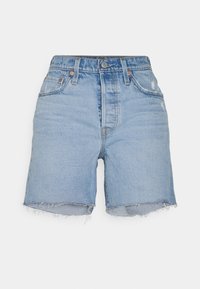 Shorts en denim bleu clair avec un ourlet brut, des détails usés, cinq poches et une braguette à boutons. Confectionnés en coton avec une texture lisse.