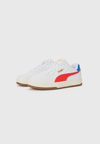 Sneakers bianchi con striscia rossa PUMA, accento blu sul tallone e suola in gomma. Punta perforata per traspirabilità, con logo giallo sulla linguetta.