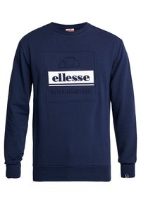 Námořnická modrá mikina s vyraženým čtvercovým logem, bílým textem "ellesse", designem v podobě půlkruhu a nápisem "ESTABLISHED 1959" pod tím.