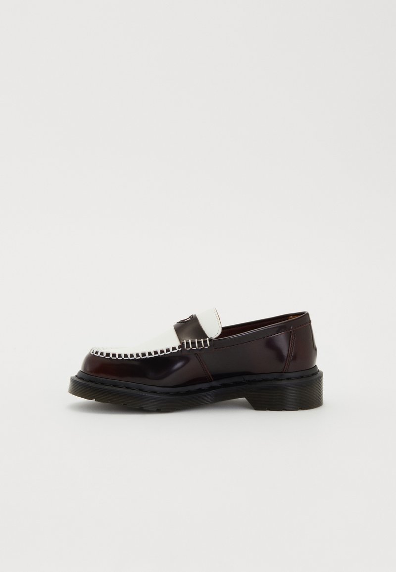 Mocassin en cuir bicolore avec une partie supérieure blanche, un corps marron foncé, des coutures contrastées et une épaisse semelle noire, présenté en vue de profil sur fond blanc.
