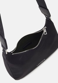 Borsa a spalla nera in nylon con zip argentata, interno verde e logo sul davanti. Presenta una tracolla larga per un indossamento comodo.