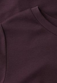 Nærbillede af mørkelilla sweatshirtstof, der viser rund halsudskæring og skuldersømme.