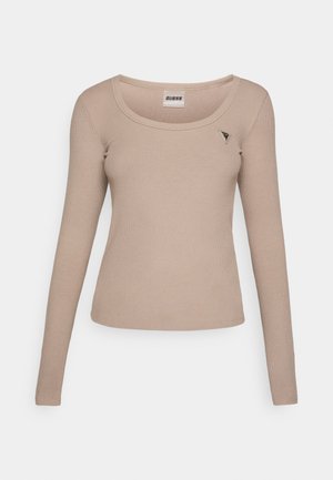 Ilgas rankovės, šviesiai kreminės spalvos palaidinė, pagaminta iš banguoto audinio. Turi apvalų iškirpimą ir mažą trikampį logotipą viršutiniame kairiajame kampe.