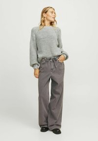 Gray knitted sweater with textured fabric, balloon sleeves, paired with high-waisted gray wide-leg jeans and black platform boots.