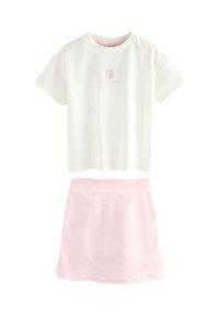 Tricou alb din bumbac cu logo "TB" roz deschis, asortat cu o fustă roz deschis dintr-un material neted. Ambele au mâneci scurte și un design simplu.