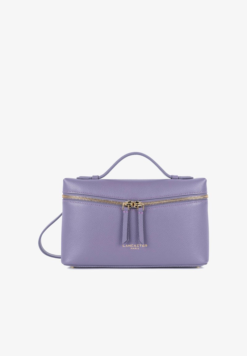 Sac à main en cuir lavande avec fermeture éclair dorée et deux curseurs, une poignée supérieure, une bandoulière, et logo "Lancaster Paris" sur le devant.