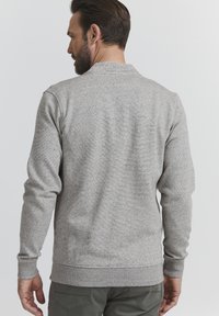 Grauer Strickpullover mit strukturiertem Muster, gerippten Bündchen und Saum. Mit Rundhalsausschnitt und langen Ärmeln, designed für Komfort.