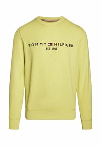 Žlutá mikina s kulatým výstřihem, dlouhými rukávy a žebrovanými manžetami. Obsahuje logo "TOMMY HILFIGER" a nápis "EST. 1985" v kontrastní černé barvě.