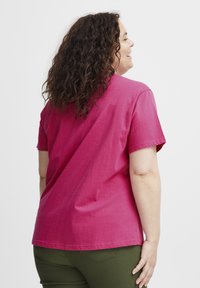 Bavlněné tričko v živé růžové barvě, krátké rukávy, kulatý výstřih, s volným střihem. Hladký materiál s jednoduchým, nezdobeným designem na zadní straně.