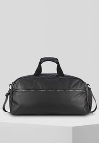 Bolso de mano negro hecho de nylon brillante con dos asas, correa de hombro ajustable y una banda de logo decorativa en la parte delantera.