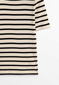 T-shirt manches courtes beige et noir à rayures horizontales avec des rayures espacées uniformément et un ourlet simple.