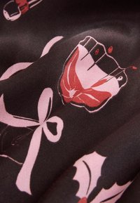 Tessuto nero con un motivo ripetuto di farfalle rosa, fiocchi e forme astratte, con diverse tonalità di rosso e una consistenza morbida.