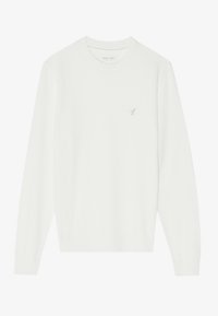Pull blanc à manches longues, fabriqué en tissu doux. Il présente un col et des poignets côtelés, avec un petit accent brodé sur la poitrine.