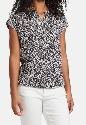 Blusa de manga corta en tejido blanco con un patrón floral en azul marino, que presenta un cuello limpio y una tapeta de botones, con un ajuste ligeramente relajado.