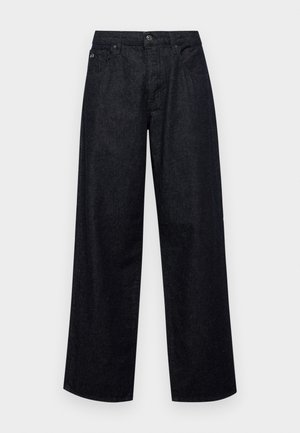 Tumedat sinised laiad teksad, mis on valmistatud denimist. Omab nupusuletust, vöökohtade jaoks silte ja esimesi taskuid. Sujuv tekstuur ning minimaalne nähtav õmblus.