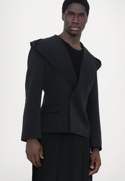 Schwarzer, taillierter Blazer mit breitem, drapiertem Kragen und langen Ärmeln. Verfügt über einen einzigen Knopfverschluss und eine Vordertasche. Glatte Textur.