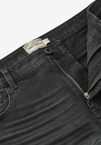 Čierne džíny z denimu s klasickým strihom, s zipsom, gombíkovým zapínaním a tkanou etiketu vo vnútri pásu.