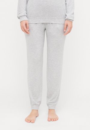 Pantalons de survêtement en coton gris avec une conception à jambe fuselée, des poignets côtelés et une texture douce. Pas de motifs visibles ni de détails en métal.