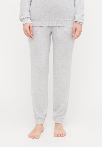 Pantalons de survêtement en coton gris avec une conception à jambe fuselée, des poignets côtelés et une texture douce. Pas de motifs visibles ni de détails en métal.