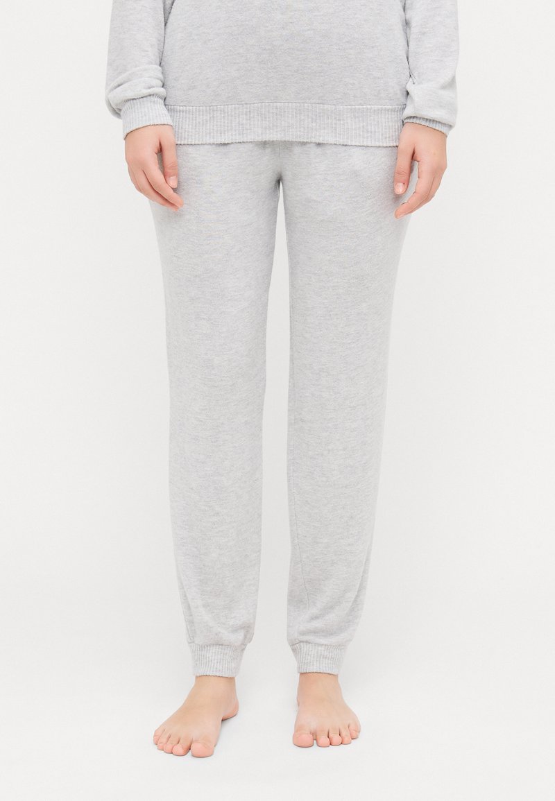 Pantalons de survêtement en coton gris avec une conception à jambe fuselée, des poignets côtelés et une texture douce. Pas de motifs visibles ni de détails en métal.