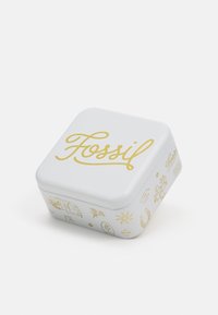 Boîte carrée en tôle blanche ornée de lettres dorées "Fossil" et de diverses illustrations dorées sur les côtés, avec une finition lisse et brillante.