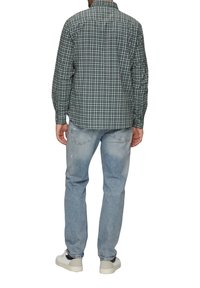 Groene en blauwe geblokte lange mouwen shirt, van katoen, met een knoopsluiting kraag, gecombineerd met lichtblauwe jeans en witte sneakers.