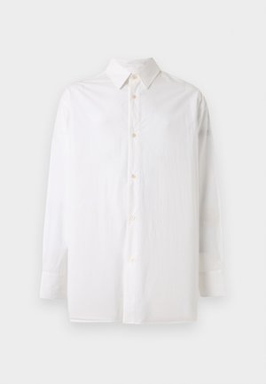 Biela košeľa s dlhým rukávom na gombíky a špicatým golierom, zobrazená na jednoduchom svetlom pozadí.