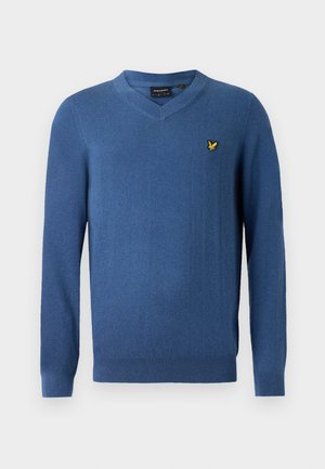 Pull bleu à col en V en tissu doux. Comprend des manches longues et un petit logo jaune brodé sur le côté gauche de la poitrine. Texture lisse.