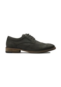 Vegan brogue shoe in dark green with perforated detailing, six eyelets, and a contrasting brown heel. Smooth textured upper material.
