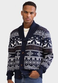 Cardigan tricotat bleu marin cu guler șal, decorat cu modele geometrice și reni în alb și maro, și cu nasturi din lemn.