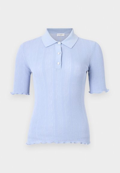 Κοντομάνικη πλεκτή πόλο μπλούζα ανοιχτό μπλε με κάθετες υφασμάτινες ρίγες, τρία κουμπιά και βολάν στα μανίκια και στη βάση.