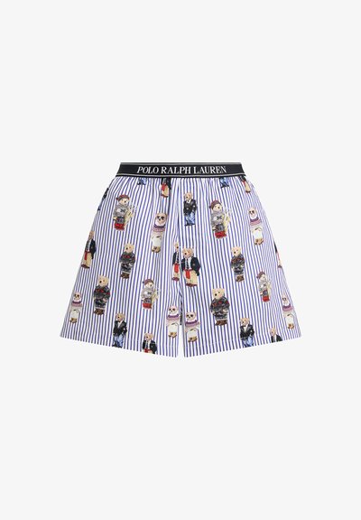 Kort bomullskjol med vertikala blå och vita ränder. Dekorerad med tecknade björnmotiv i olika kläder. Elastiskt svart midjeband.